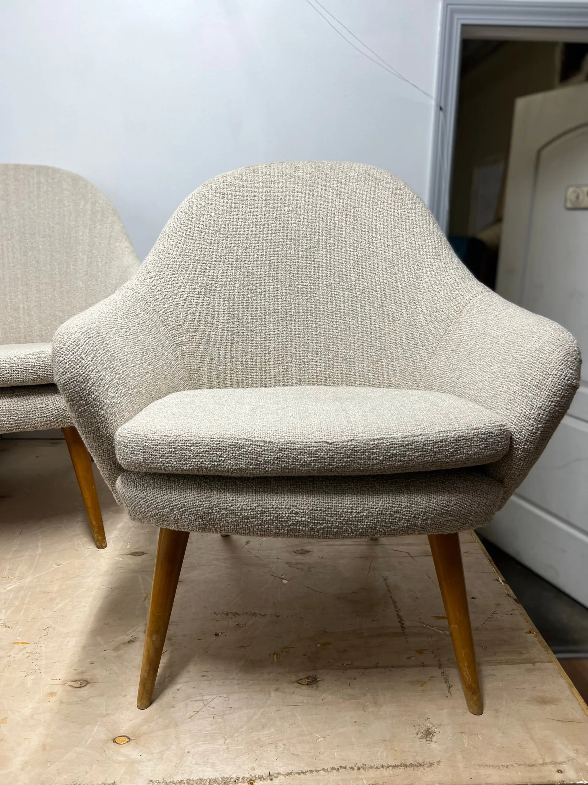 Pair of mid-century lounge chairs reupholstered in natural bouclé