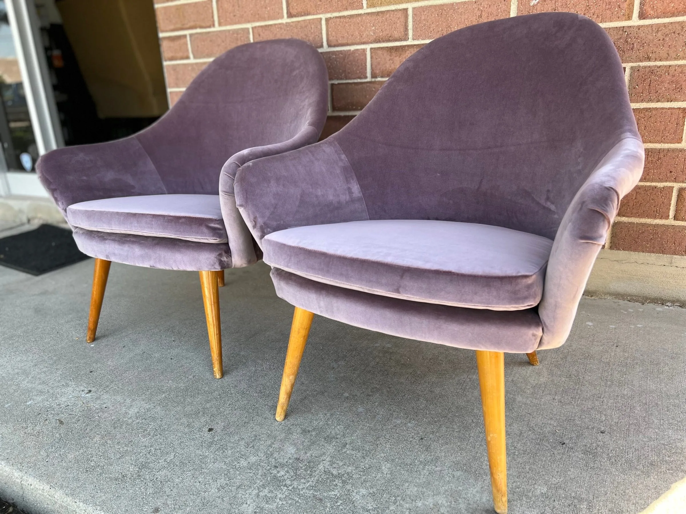Two mid-century armchairs reupholstered in rich purple velvet