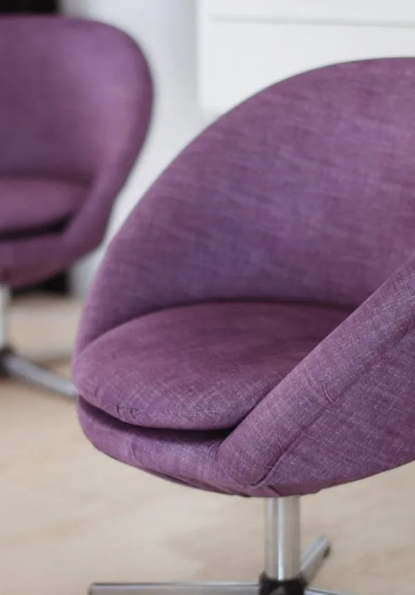 Close-up detail of modern round swivel chairs reupholstered in purple linen